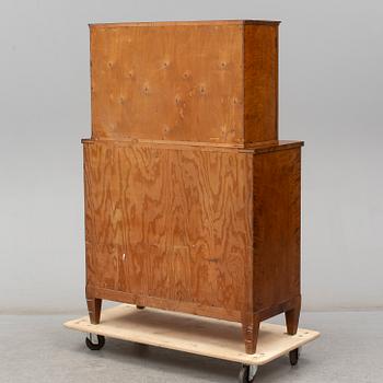 a chest of drawers with a vitrine cabinet from the early 20th century.
