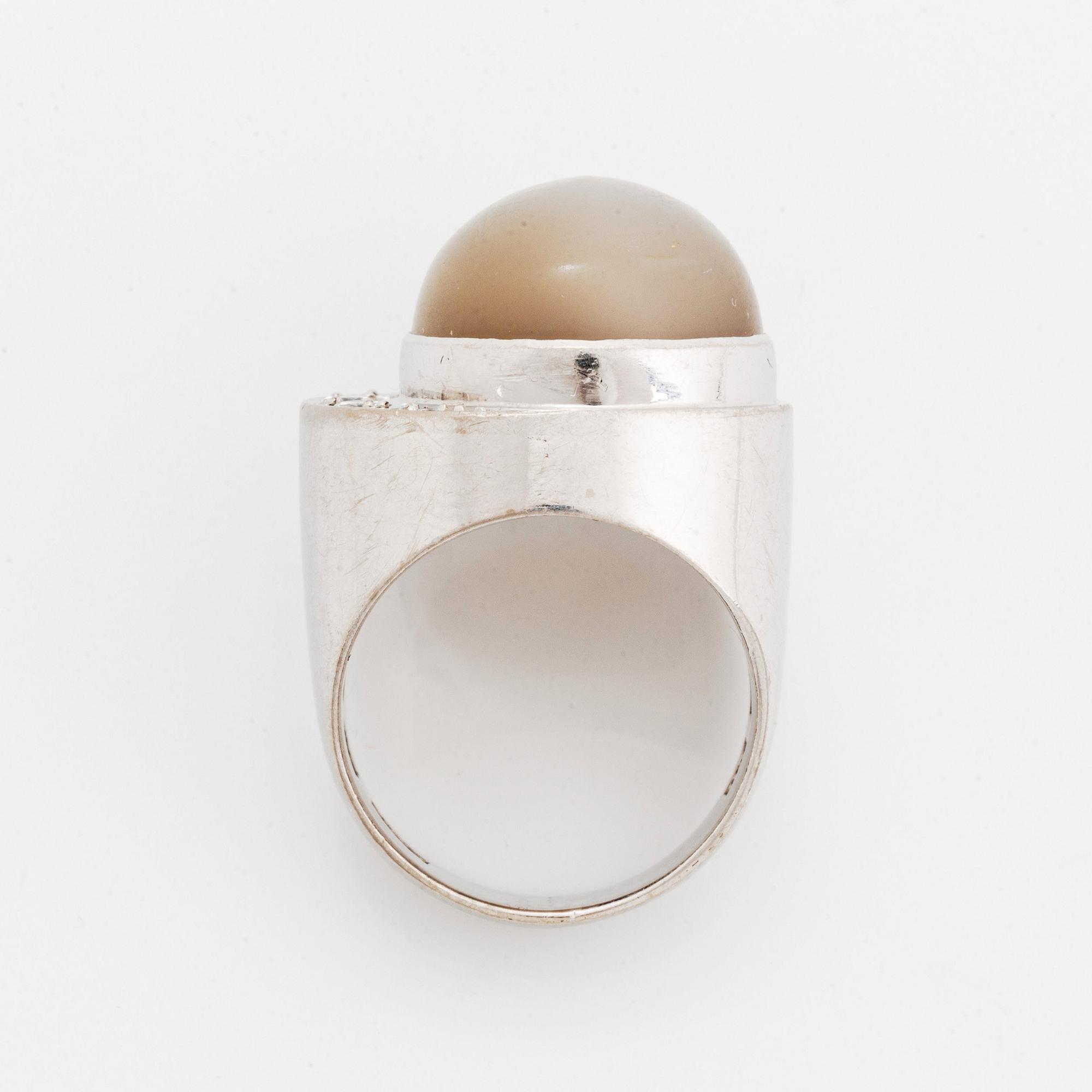 Ring 18K vitguld med en cabochonslipad månsten och runda briljantslipade diamanter.
