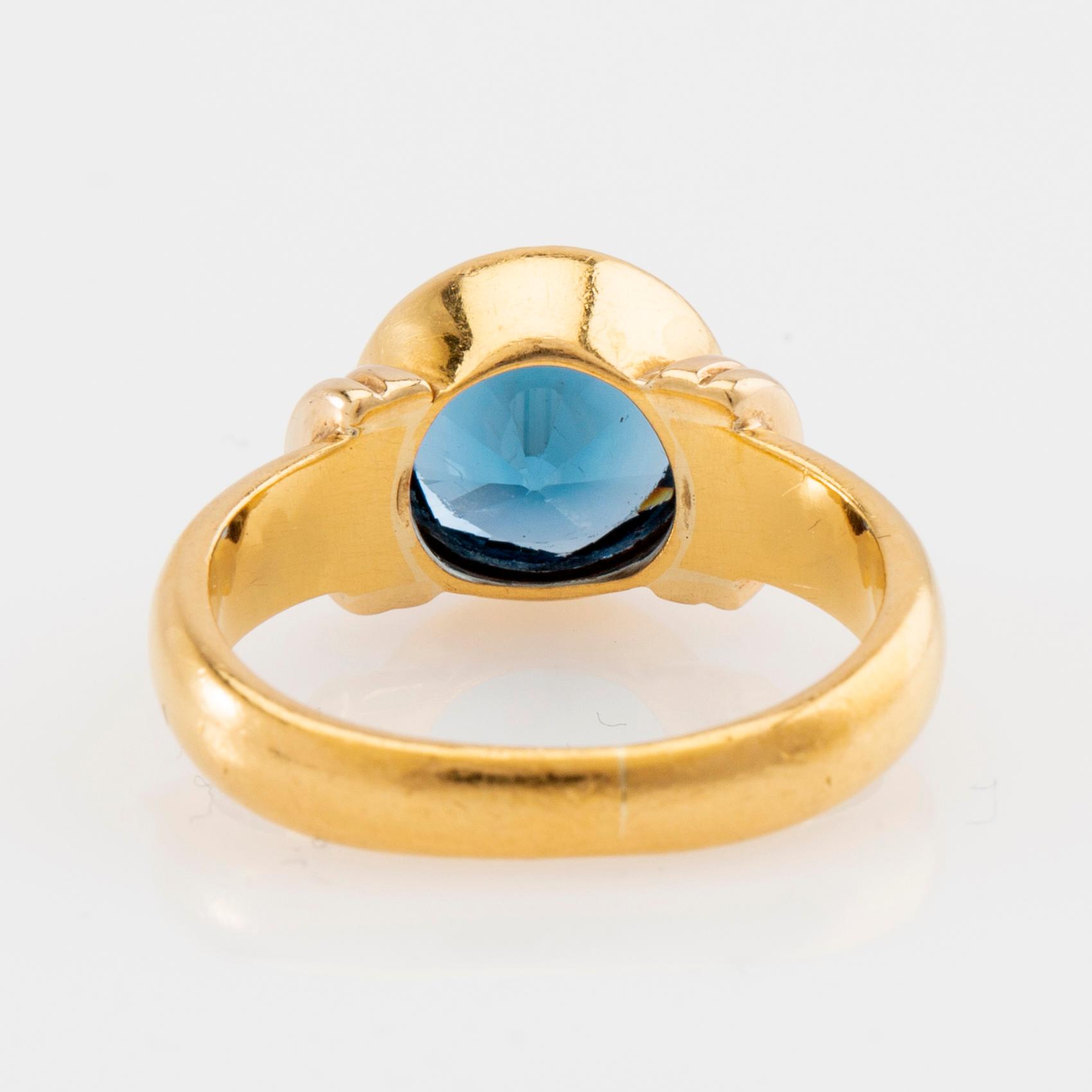 Ring 18K guld med fasetterat blått glas.