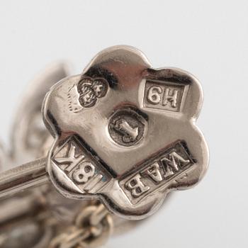 Ett par örhängen, med droppformade smaragder och diamanter.