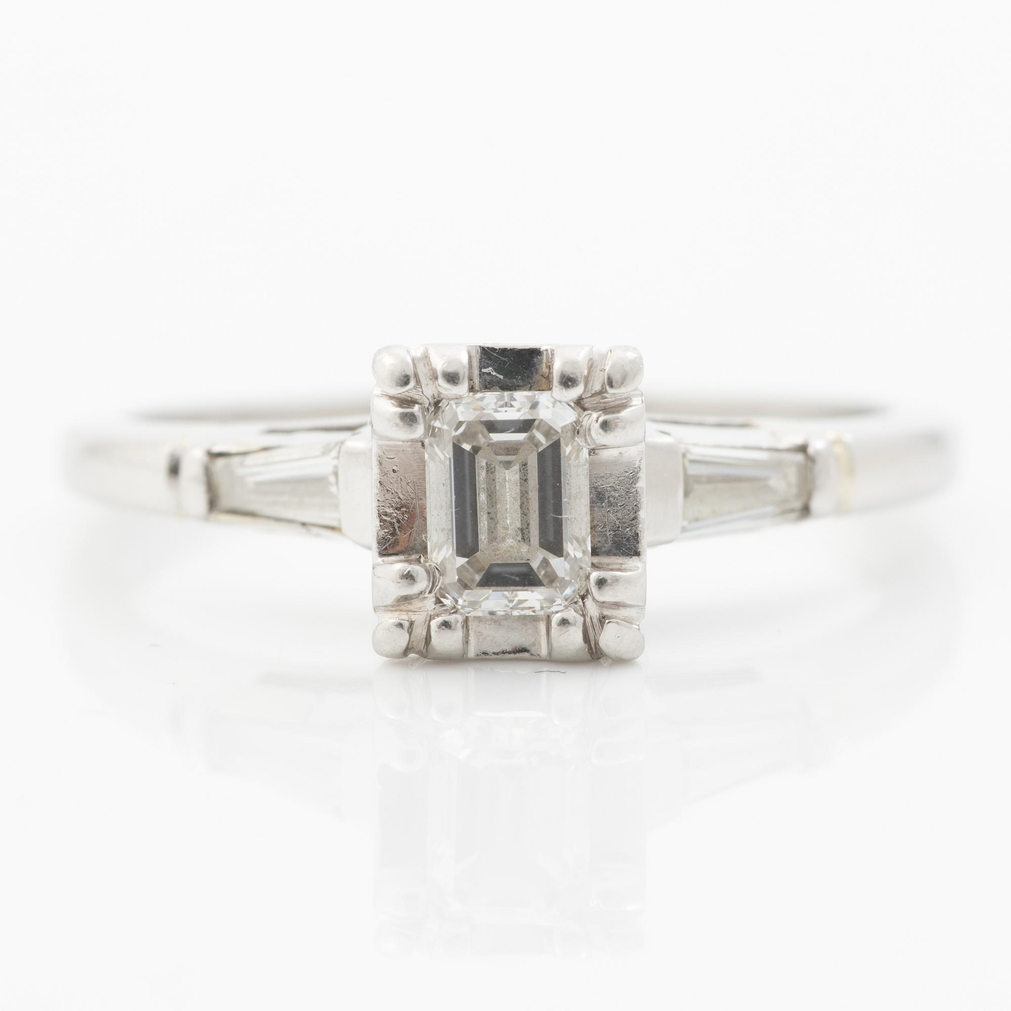 Platinum ring with an emerald-cut diamond and modified baguette-cut diamonds.