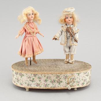 Dolls on a music box, around year 1900.