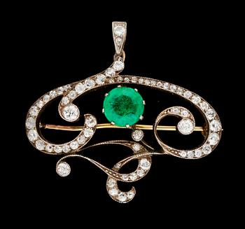 724. BROSCH/HÄNGE, guld med rund fasetterad smaragd och diamanter, tot. ca 1.35 ct. Art Nouveau.