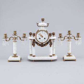 A French mantlepiece clock and a pair of candelabras, first half of the 20th century.