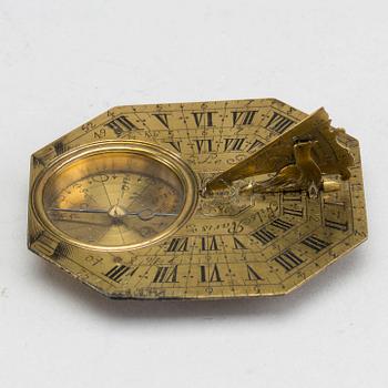 A brass travel sundial marked Le Maire et Fils Paris around 1700.