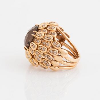 An 18K gold and smoky quartz ring set with round brilliant-cut diamonds.