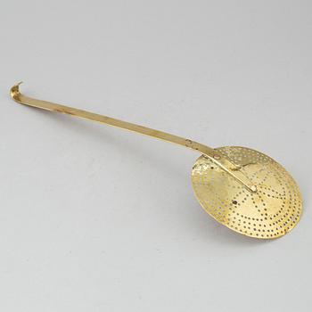 An 18th century brass strainer.