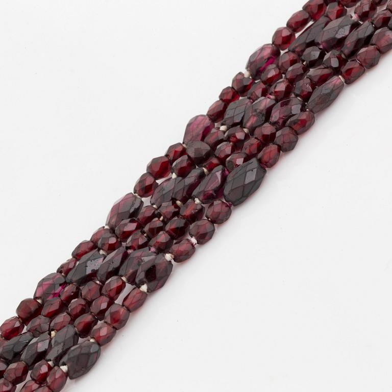 A five strand garnet necklace with a 14K gold clasp set with garnets.