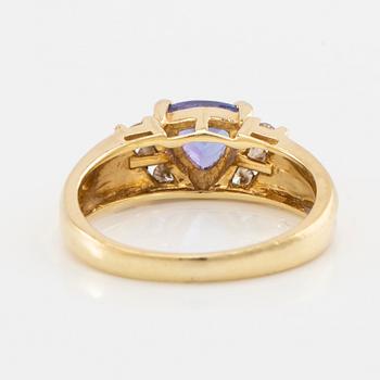 Ring in 18K gold set with a faceted tanzanite and round brilliant-cut diamonds.