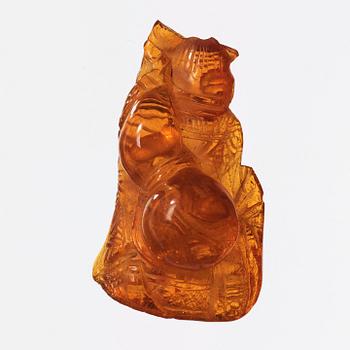 An amber pendant in the shape of a seated man, Qing dynasty (1644-1912).