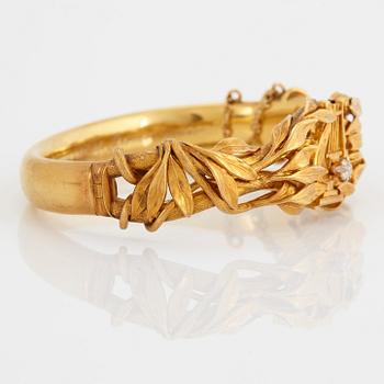 An 18K gold bangle set with an old-cut diamond.