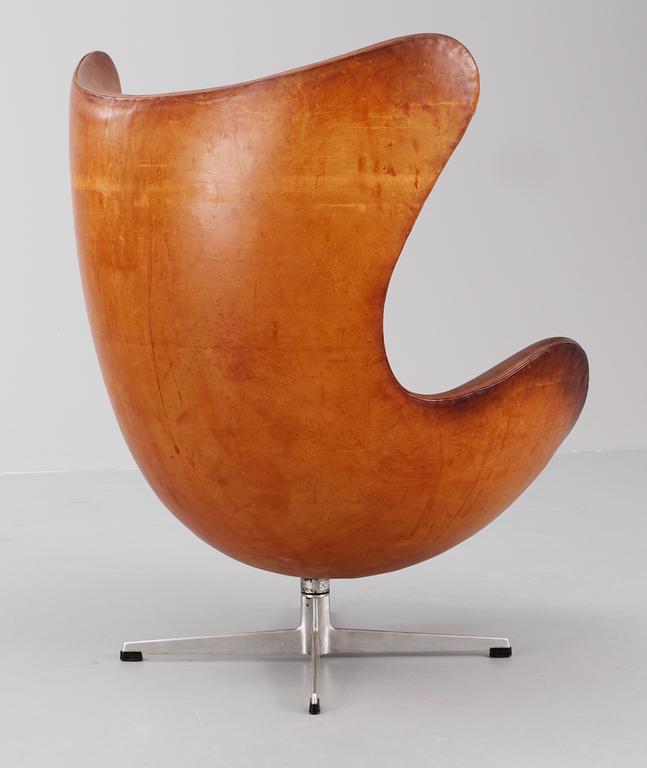 An Arne Jacobsen brown leather 'Egg chair' with ottoman, by Fritz Hansen, Denmark 1963.