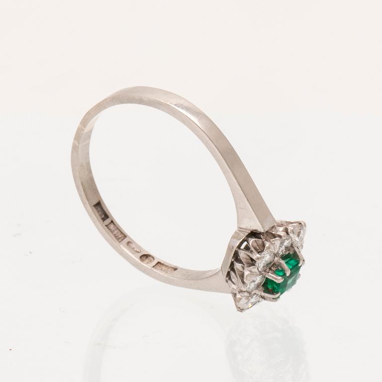 An 18K white gold ring set with a step cut emerald and round brilliant cut diamonds, Stockholm 1964.