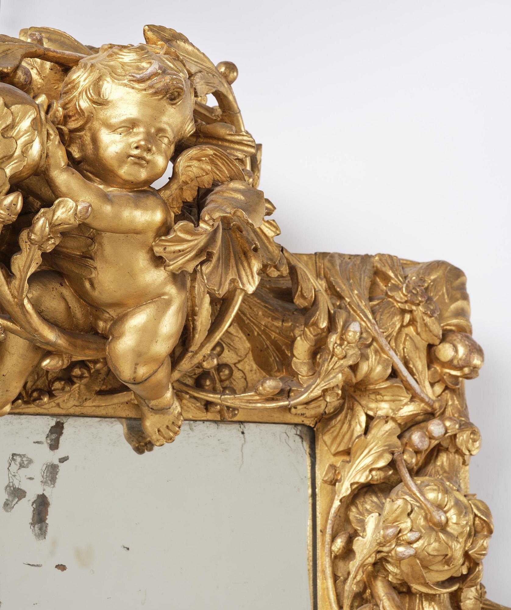 A presumably Dutch Louis XIV carved giltwood frame with mirror glass, in the style of Jean Le Pautre, late 17th century.
