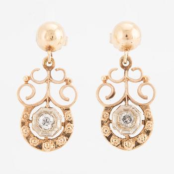 A pair of earrings in 14K gold set with round brilliant-cut diamonds.