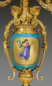 A pair of seven-light gilt bronze chandelabras with porcelain settings, 19th Century, presumably Russian.