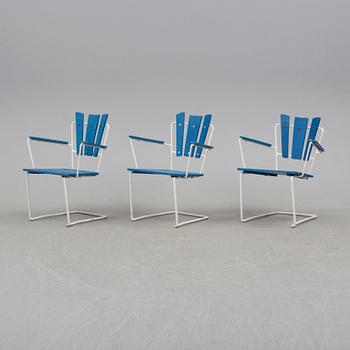 A mid 20th century garden table and three chairs.