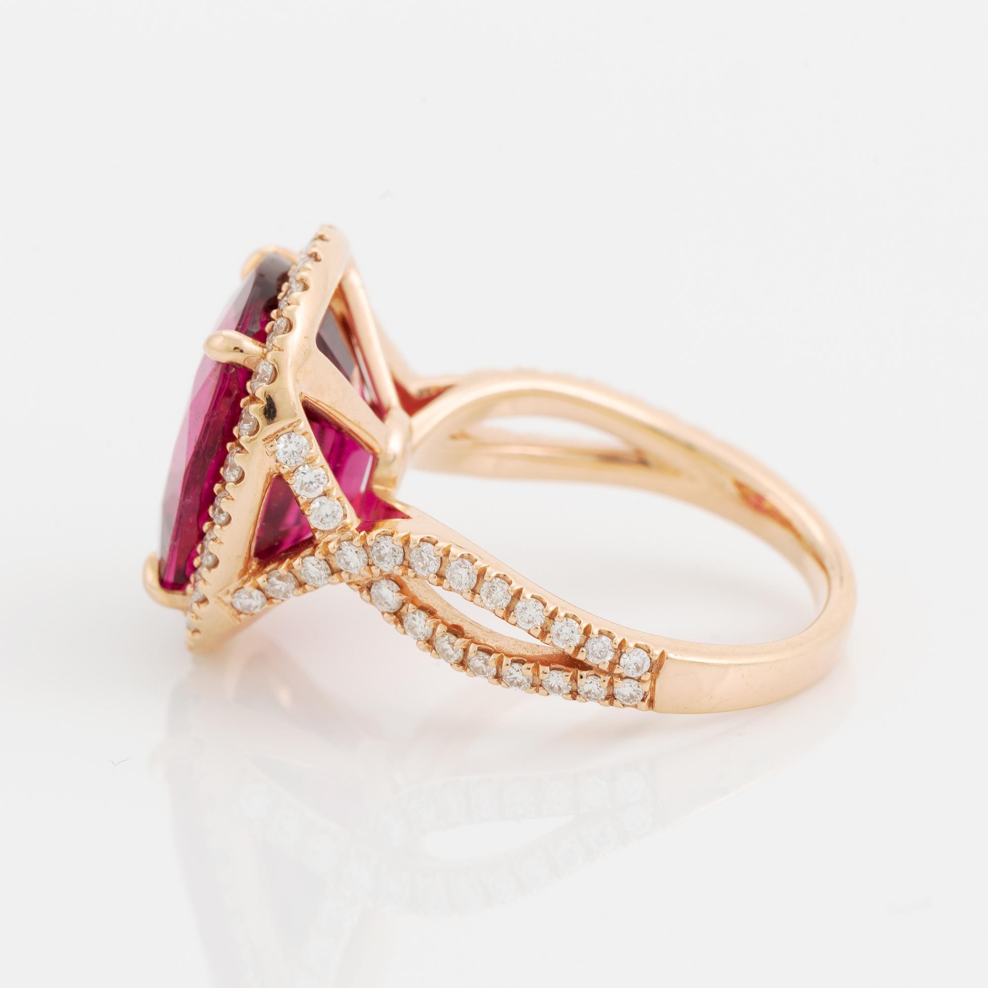 An 18K gold ring set with a faceted pink tourmaline and round brilliant-cut diamonds.