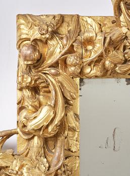 A presumably Dutch Louis XIV carved giltwood frame with mirror glass, in the style of Jean Le Pautre, late 17th century.