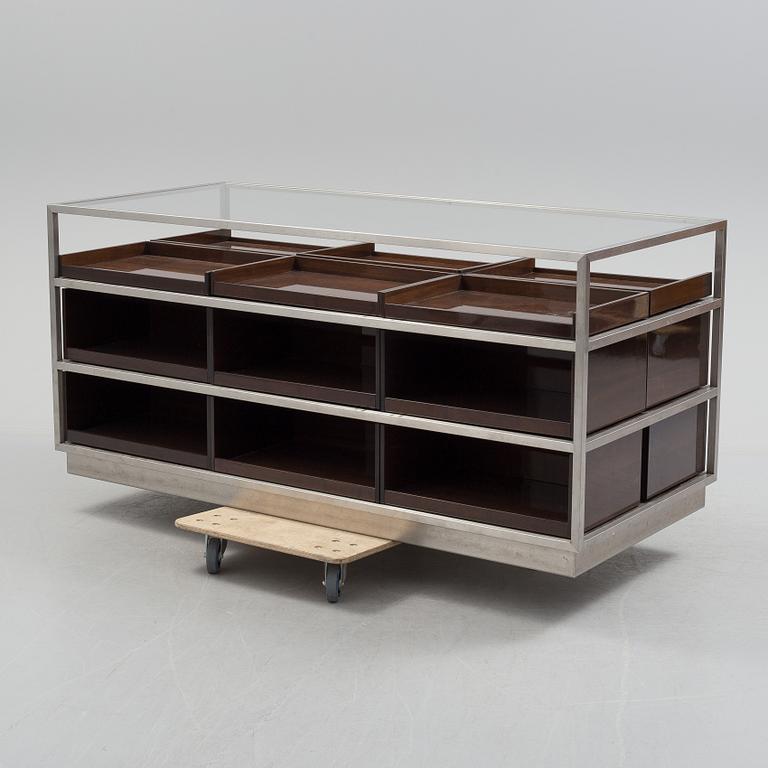 A modern glass and metal cabinet for shop use.