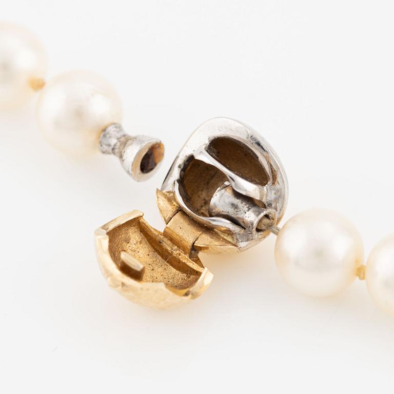 Ole Lynggaard, clasp in 18K gold, with three colliers featuring cultured pearls.