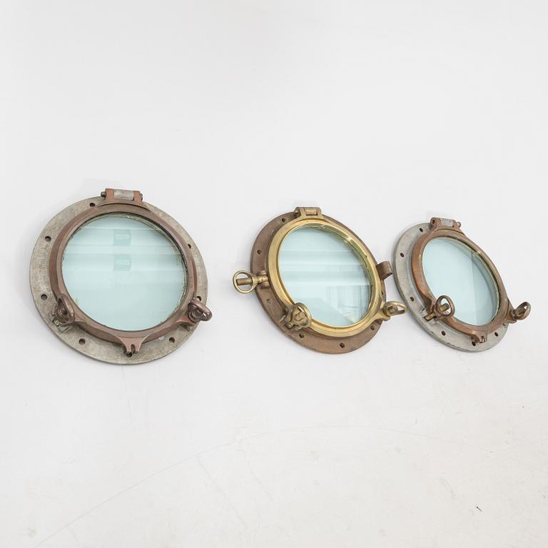 A set of three brass and metal ships windows possibly England 20th century.