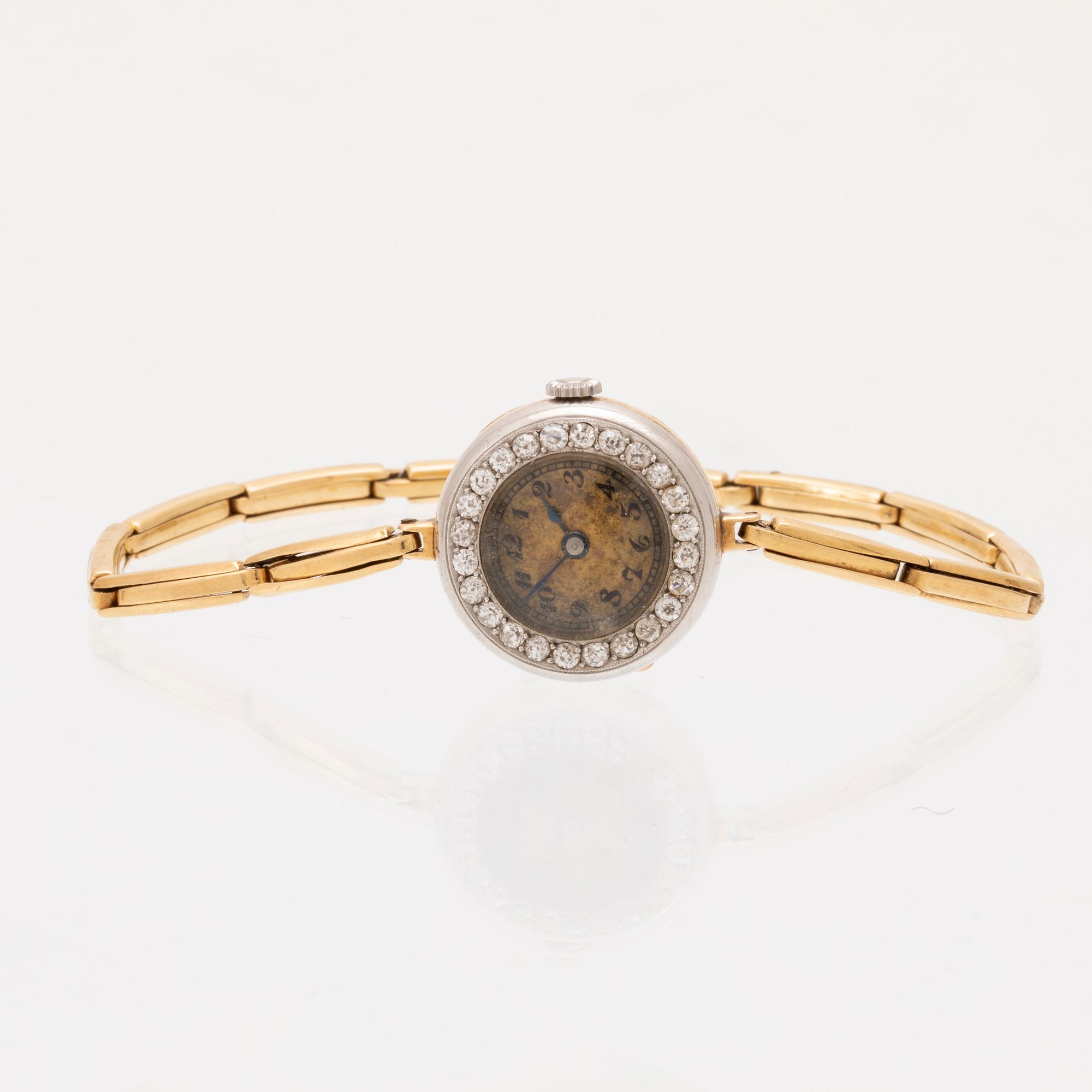 An 18K white and red gold watch set with round old cut diamonds.