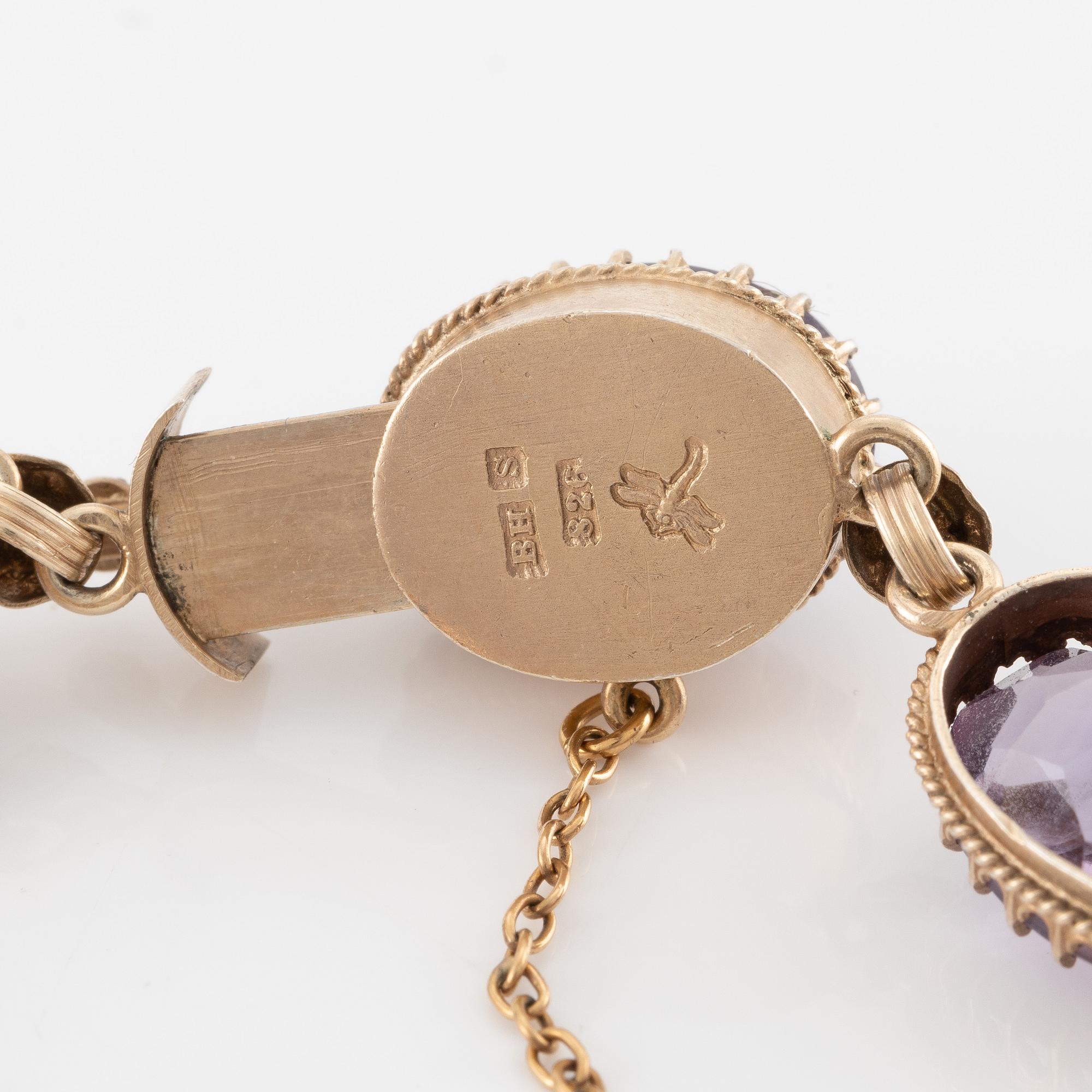 A set with a necklace, a bracelet, a brooch, and a ring.