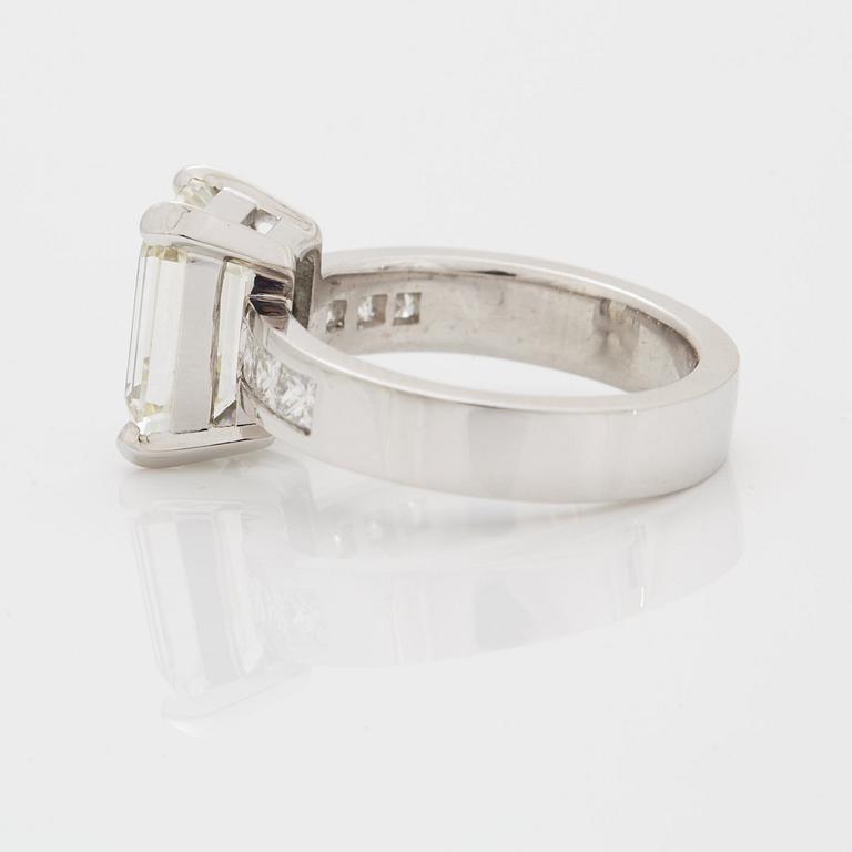 A RING set with an emerald-cut diamond.