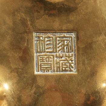 A polished bronze tripod censer, Ming dynasty (1368-1644).