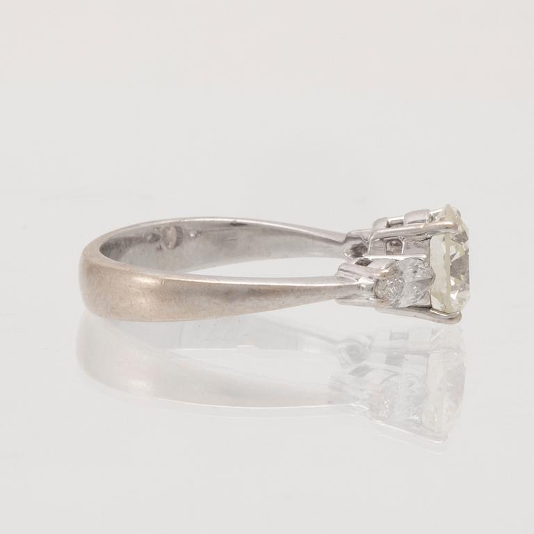 An 18K white gold ring set with one round brilliant-cut diamond and two marquise-cut diamonds.