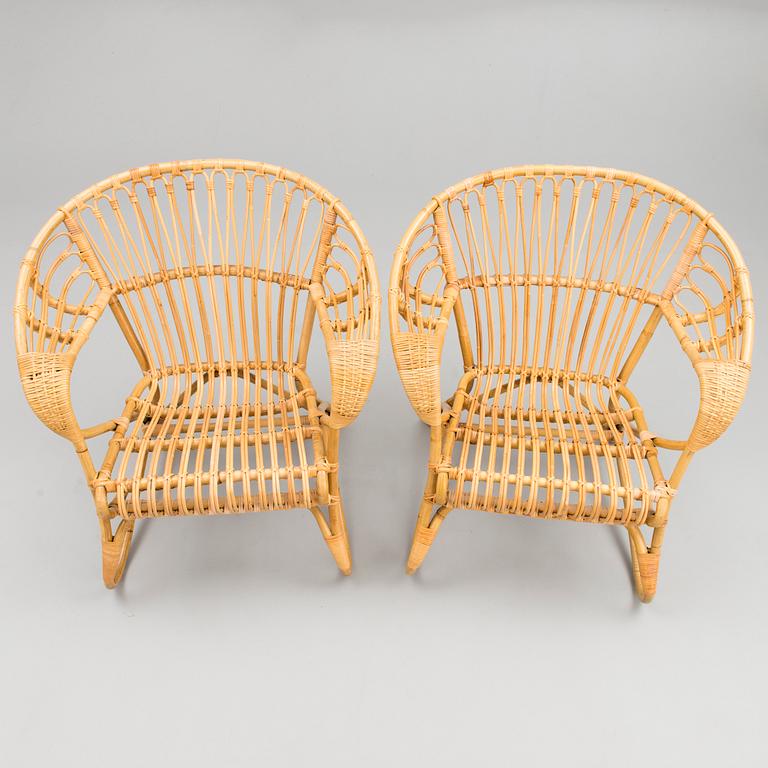 A pair of rattan arm chairs from the latter half of the 20th Century.