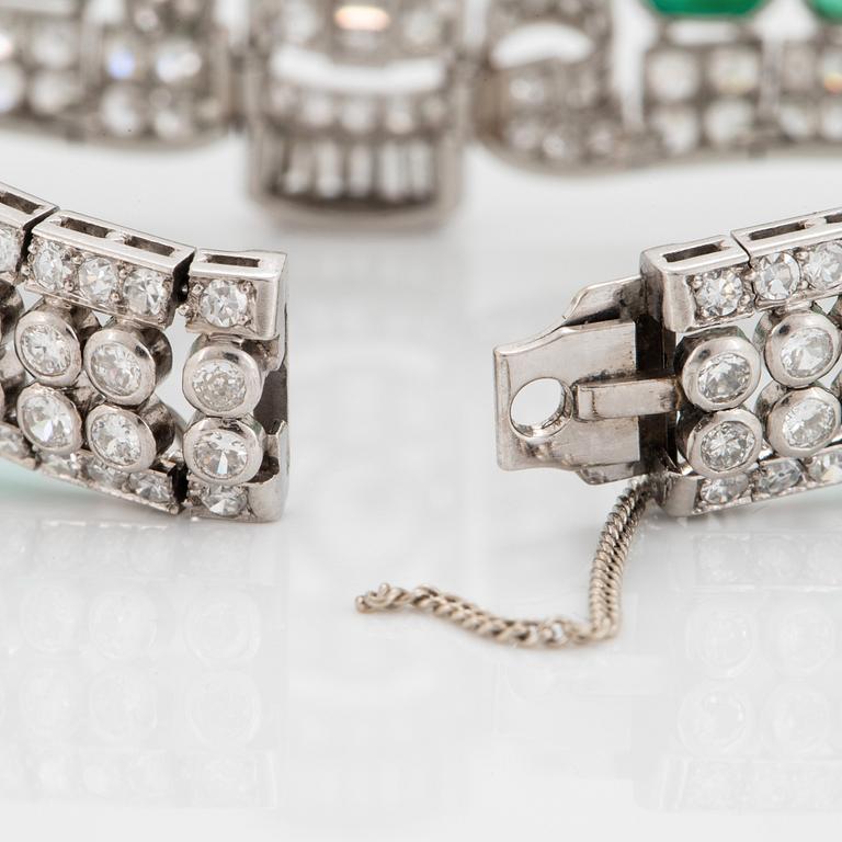 A platinum bracelet set with cabochon-cut emeralds and old-, eight- and baguette-cut diamonds.