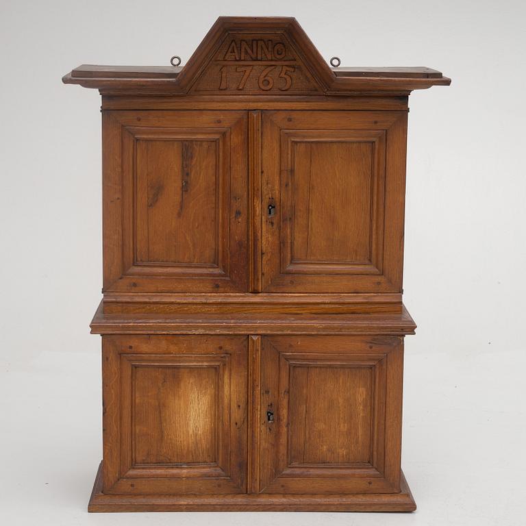 A wall cabinet, dated 1765.