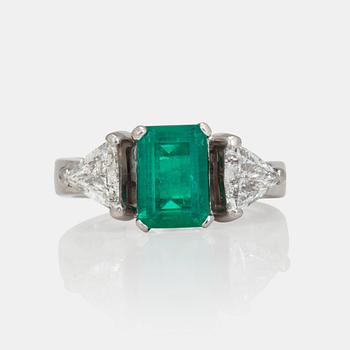 1222. A circa 1.85ct emerald and trilliant-cut diamond ring.