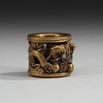 A gilt bronze archers ring decorated with separately fused and inserted dragons, Qing dynasty (1644-1912).