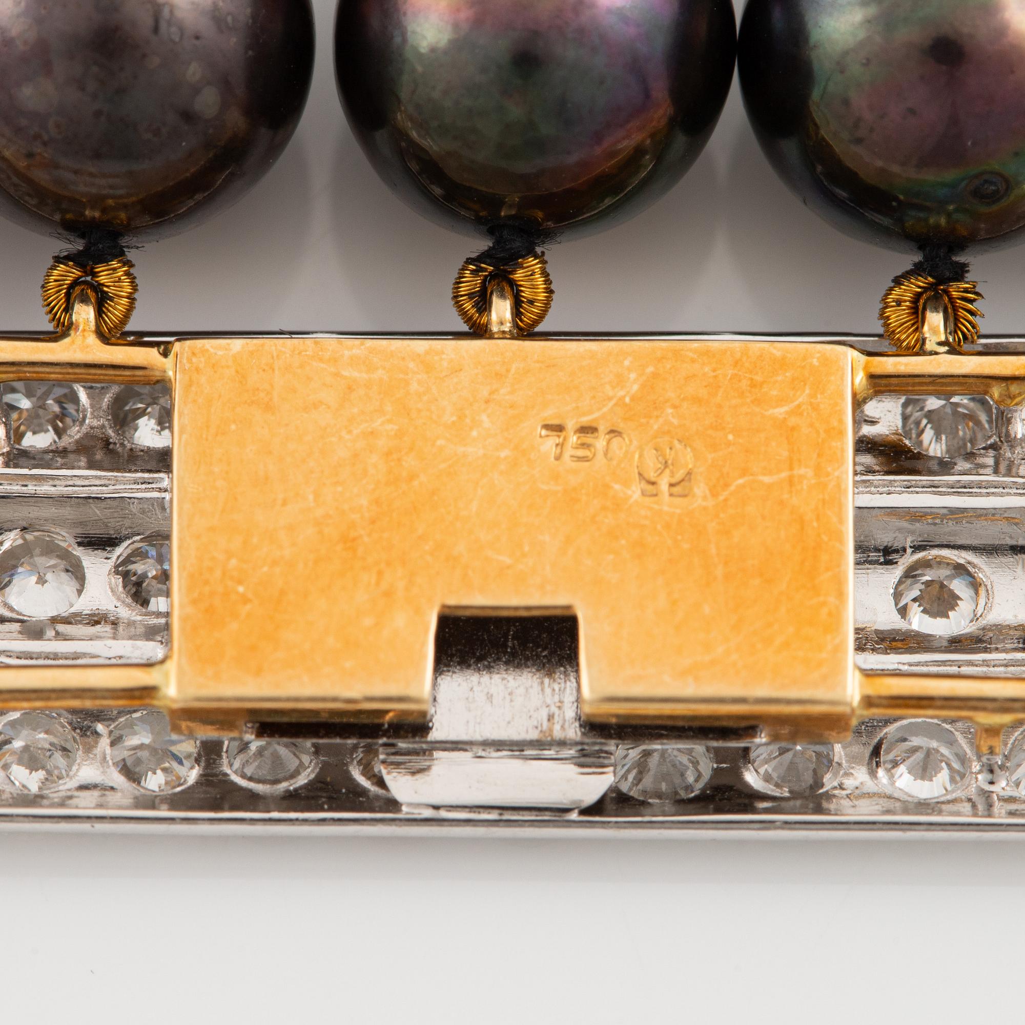 Bracelet with five rows of cultured black pearls, clasp in 18K gold and white gold set with brilliant-cut diamonds.