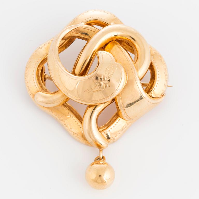 An 18K gold brooch.