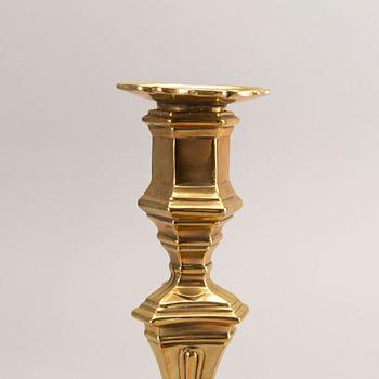 A pair of rococo brass candlesticks, possibly France.