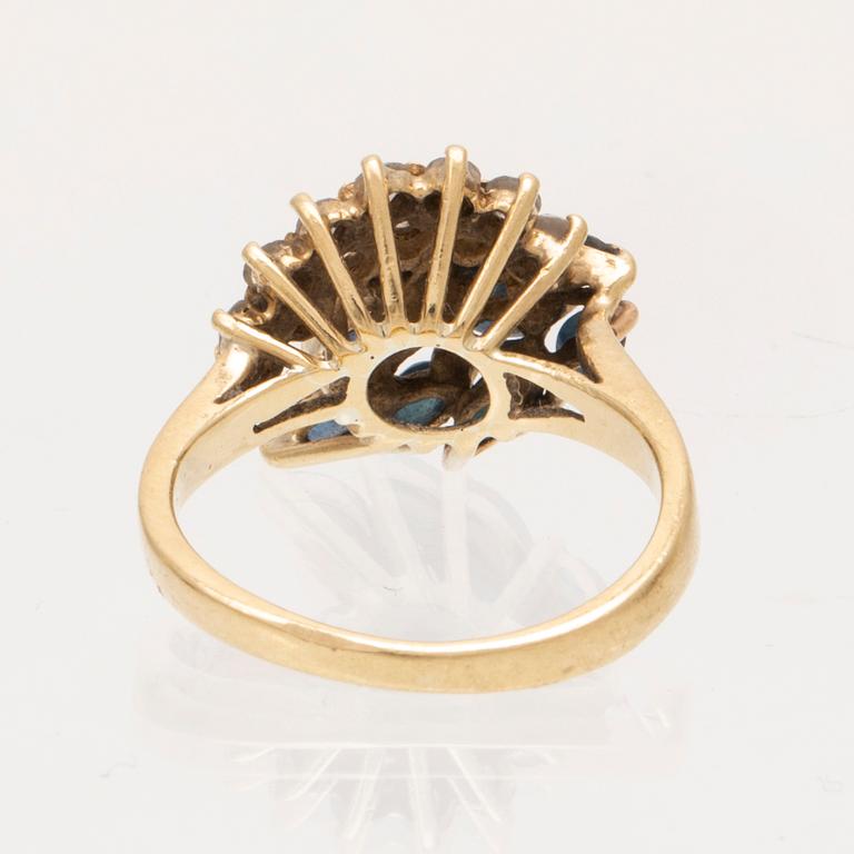 An 18K gold ring with marquise cut sapphires and round brilliant cut diamonds.