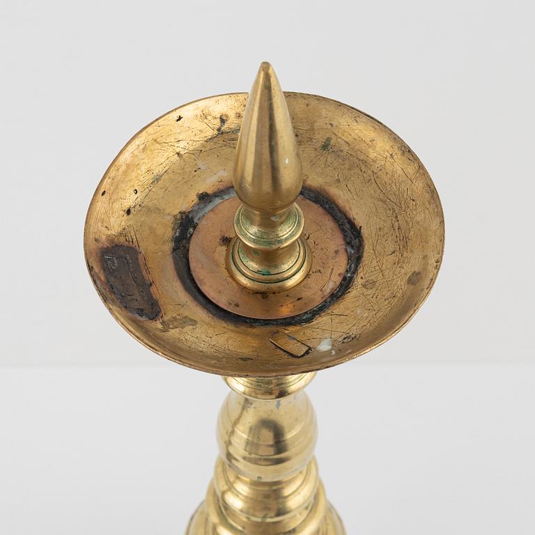 A pair of brass candle sticks, around 1700.
