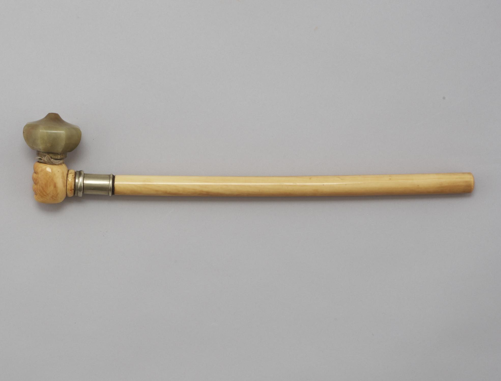 A carved ivory and green stone opium pipe with metal mount, late Qing dynasty (1644-1912).