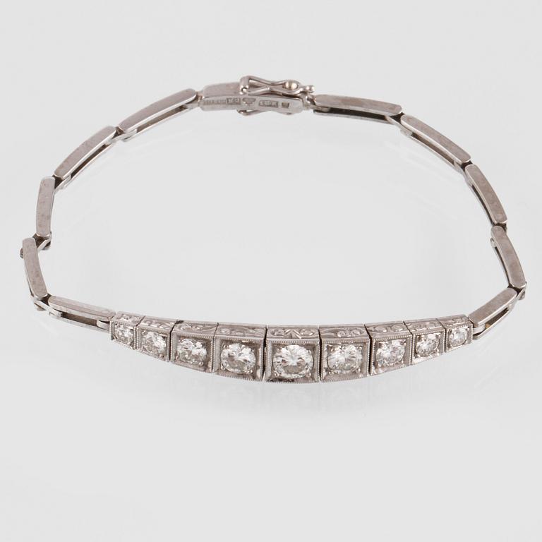 ARMLÄNK, vitguld med 9 briljantslipade diamanter, ca 0.99 ct,  Gustav Dahlgren & Co, Malmö, 1955. Vikt 9,8 gram.
