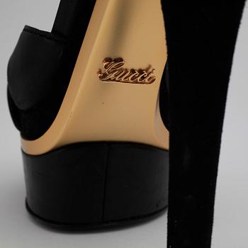 GUCCI, a pair of black leather platform sandalettes.