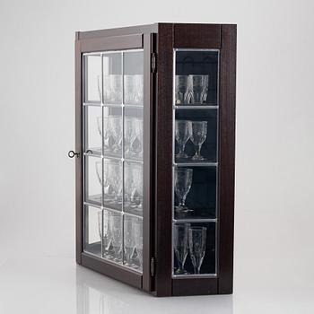 A display cabinet with a 47-piece glass service, "Koskull" from Kosta, Sweden.