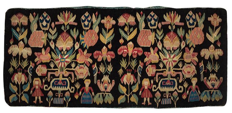 A carrige cushion, "Urnor och par", tapestry weave, ca 105 x 46 cm, around the years 1790-1810.