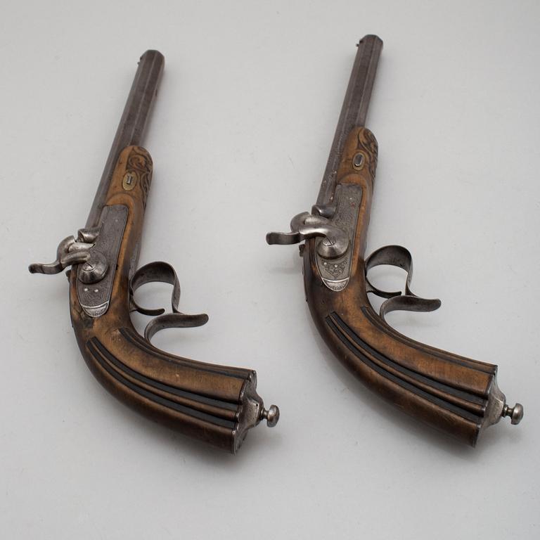 A pair of mid 19th century percussion pistols in a case marked Campagnac a Bordeaux.