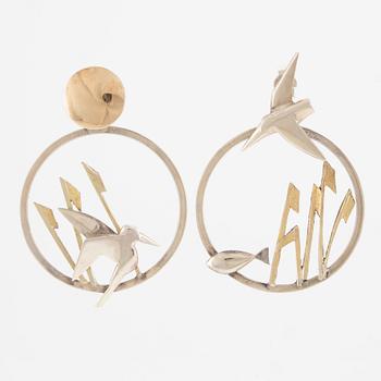 A pair of earrings featuring birds and fish, silver with gold detail.