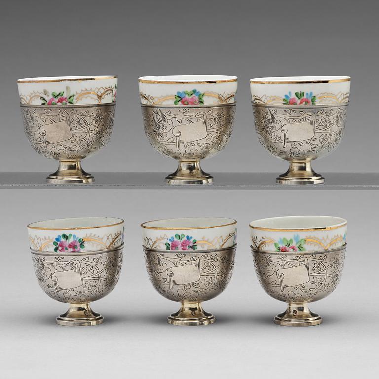 A set of six Ottoman parcel-gilt silver Xarfs with Russian Kuznetzov porcelain cups, c. 1910.