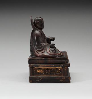 A lacquered wooden Japanese deity on a stand, 19th Century.